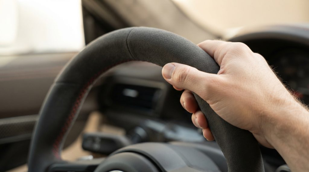 Microfibra acamurçada tipo Alcântara cinzento escuro num volante desportivo com costura de contraste